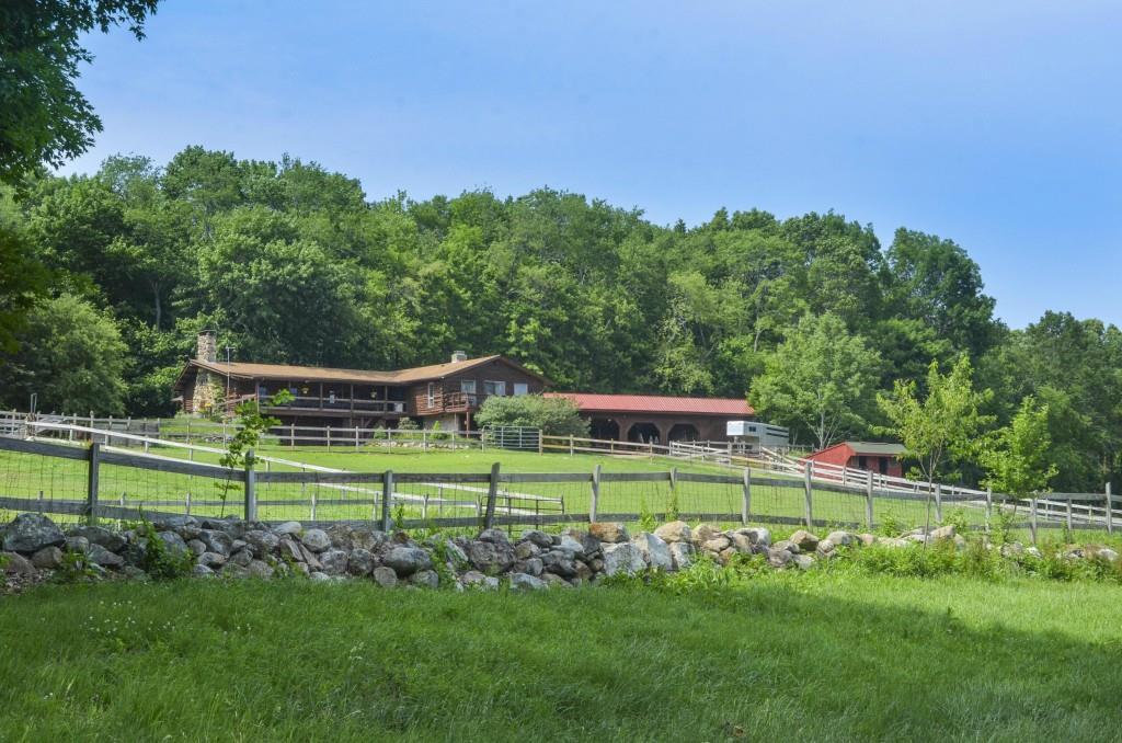 a view of a house with a big yard and a large trees