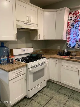 a kitchen with granite countertop white cabinets and white appliances