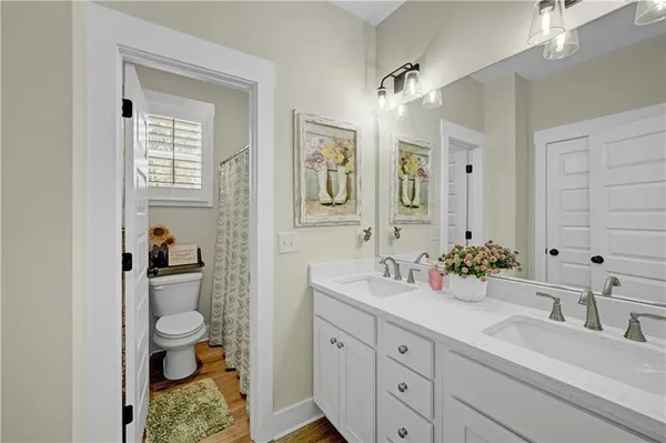 a bathroom with a sink a toilet and a mirror