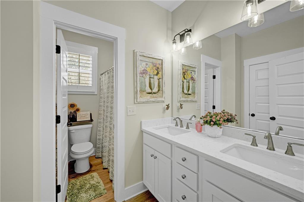670 Poplar Street Monroe, GA 30655 - Photo 17 of 26 a bathroom with a sink a toilet and a mirror