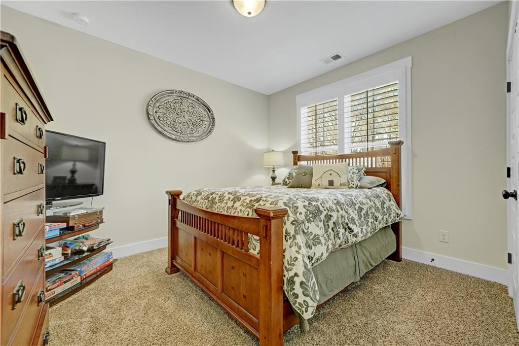 670 Poplar Street Monroe, GA 30655 - Photo 18 of 26 a bedroom with a bed and a flat screen tv