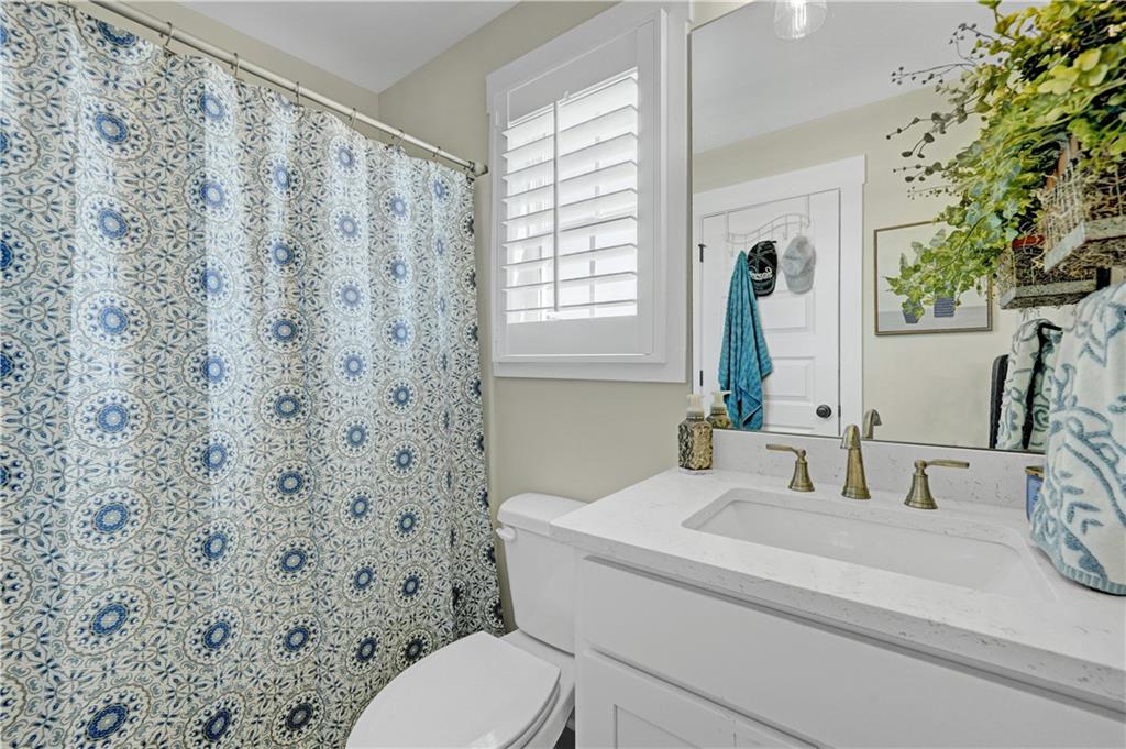 670 Poplar Street Monroe, GA 30655 - Photo 10 of 26 a bathroom with a sink a toilet and a mirror