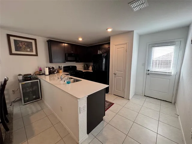 a kitchen that has a sink a stove and a refrigerator