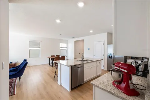 a kitchen with granite countertop a sink stainless steel appliances and cabinets