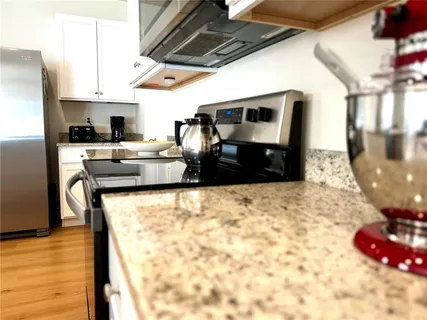 a kitchen with stainless steel appliances granite countertop a sink and a stove