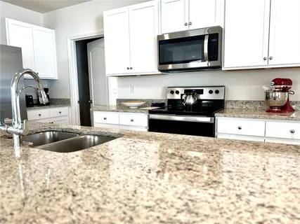 a kitchen with a sink stove top oven and refrigerator