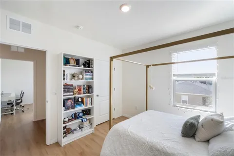 a bedroom with a bed and a flat tv screen on dresser