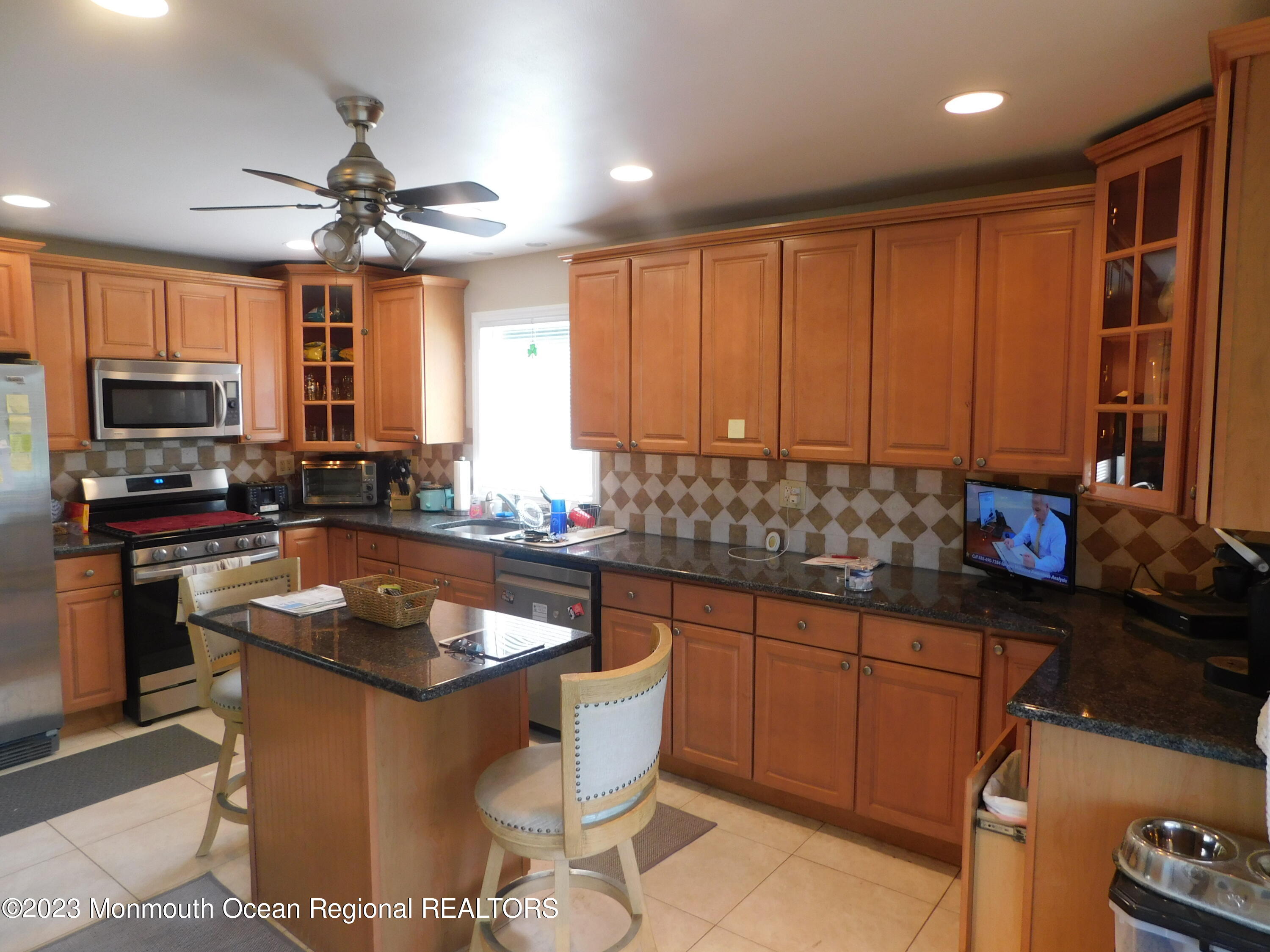 295 Broadway Freehold, NJ 07728 - Photo 2 of 39 a kitchen with granite countertop kitchen island stainless steel appliances a sink a stove a counter top space cabinets and a window