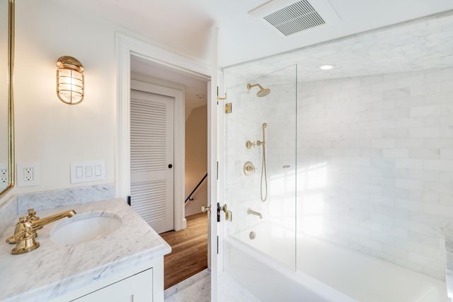 a bathroom with a tub sink and mirror