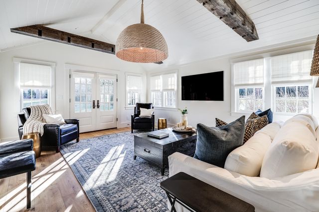 a living room with furniture a ceiling fan and a flat screen tv