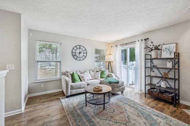 a living room with furniture a rug and a window