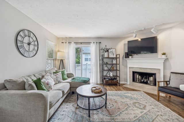 a living room with furniture a flat screen tv and a fireplace