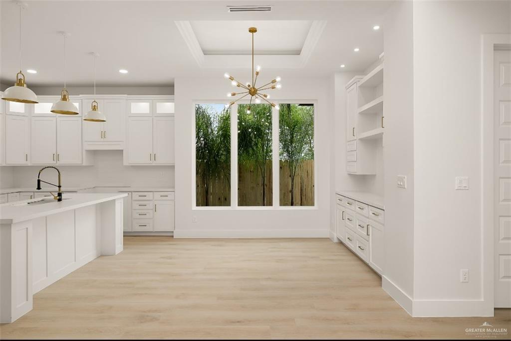 8003 North 55th Lane McAllen, TX 78573 - Photo 8 of 20 a large white kitchen with granite countertop a large window and white cabinets
