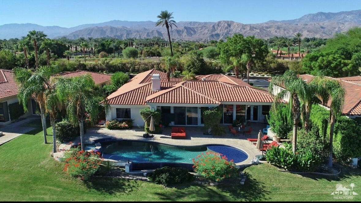 104 Loch Lomond Road Rancho Mirage, CA 92270 - Photo 2 of 27 a view of a patio with table and chairs potted plants and a large tree