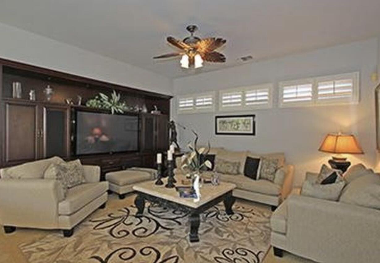 104 Loch Lomond Road Rancho Mirage, CA 92270 - Photo 23 of 27 a living room with furniture a chandelier and a flat screen tv