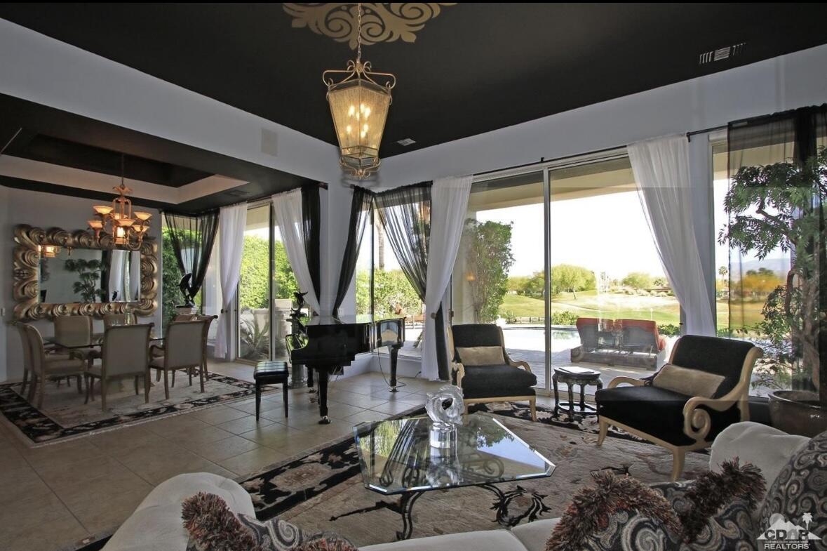 104 Loch Lomond Road Rancho Mirage, CA 92270 - Photo 6 of 27 a living room with furniture large windows and wooden floor
