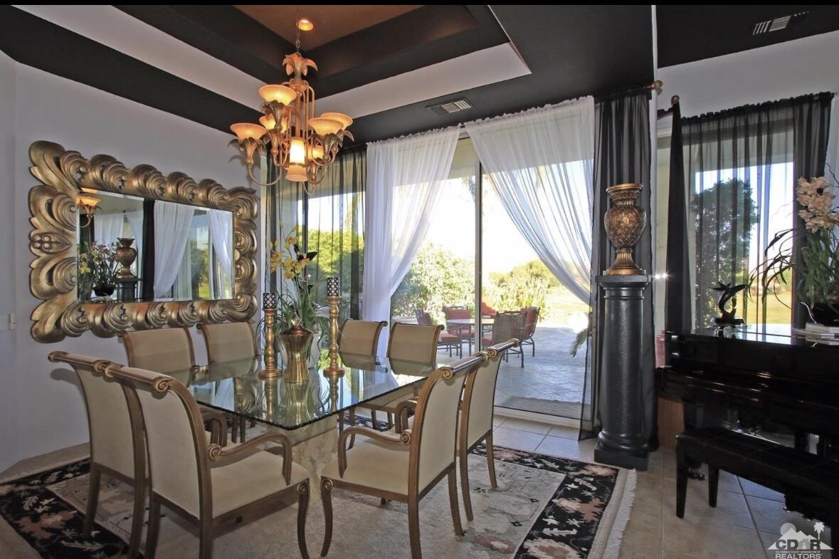104 Loch Lomond Road Rancho Mirage, CA 92270 - Photo 7 of 27 a view of a dining room with furniture wooden floor and chandelier