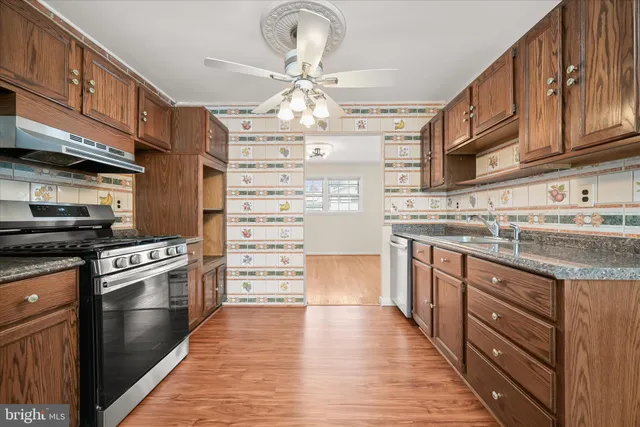 a kitchen with stainless steel appliances granite countertop a sink and cabinets