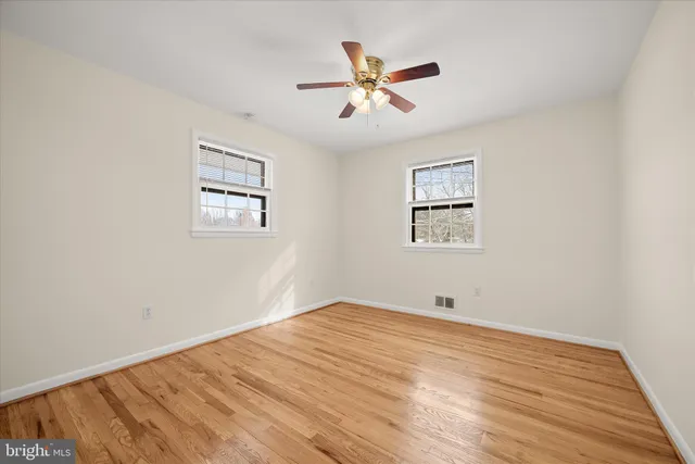 a view of a big room with wooden floor and windows
