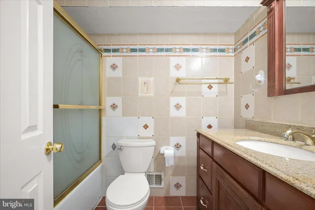 a bathroom with a granite countertop sink toilet and shower