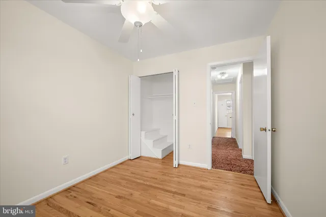 a view of a room with wooden floor and ceiling fan