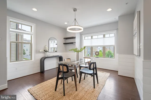 a dining room with furniture a chandelier and wooden floor