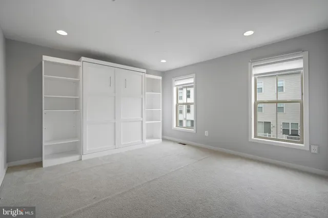 an empty room with windows and closet