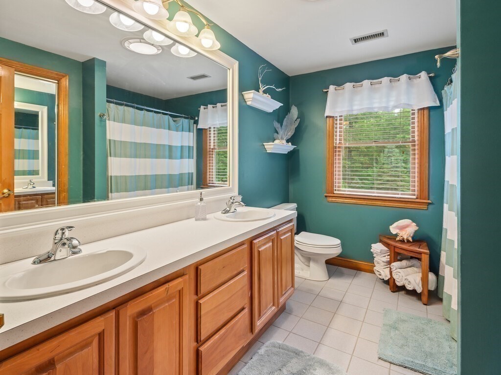 9 Santom Street Auburn, MA 01501 - Photo 23 of 42 a bathroom with a granite countertop sink a toilet and a mirror