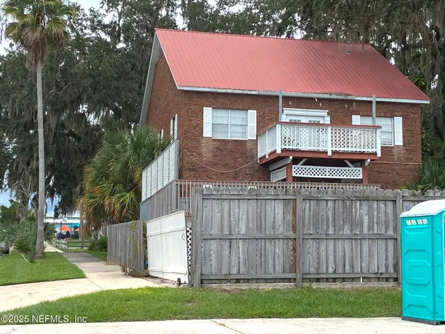 a view of a balcony with wooden floor and fence