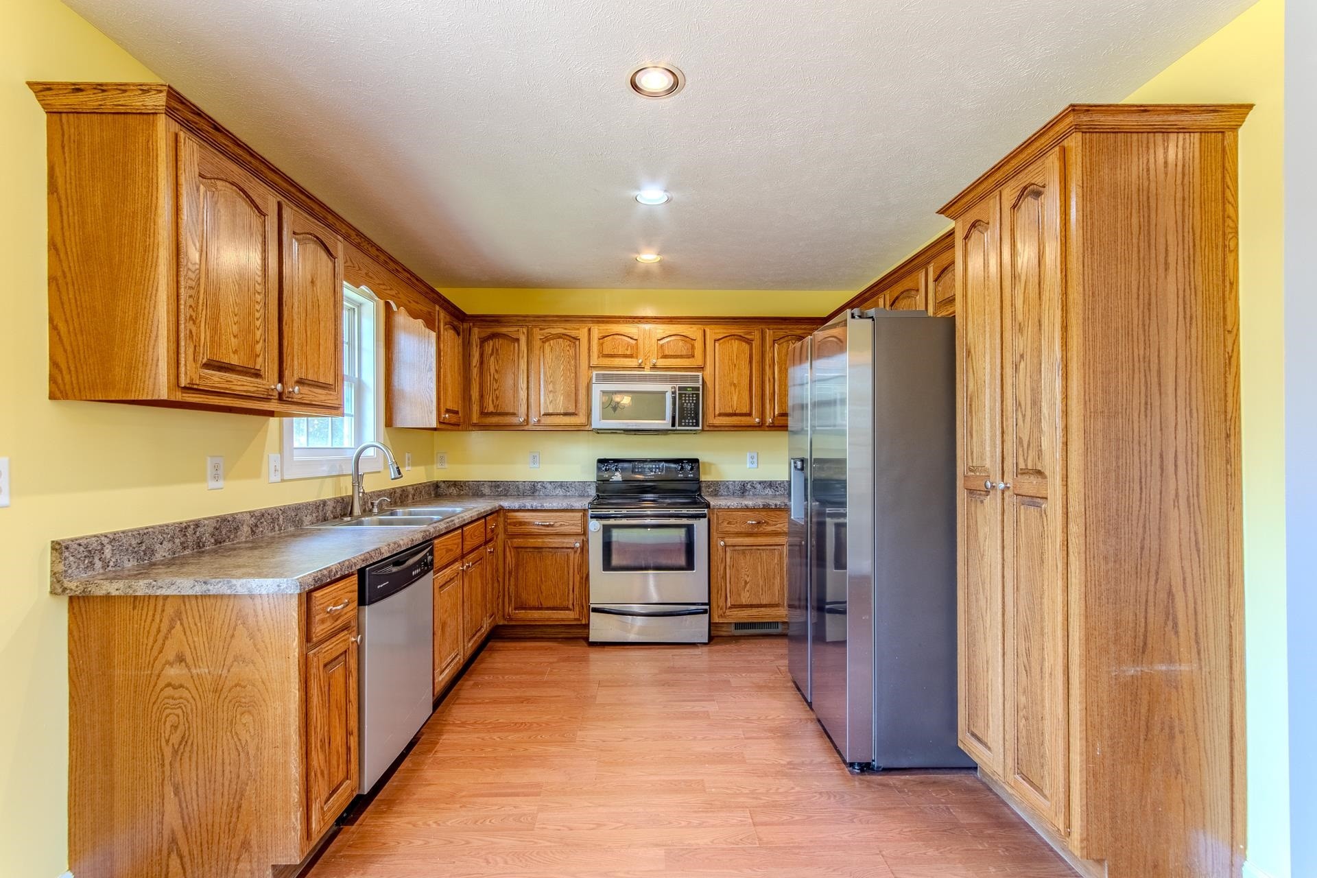 150 Hollis Way Adamsville, TN 38310 - Photo 14 of 37 a large kitchen with stainless steel appliances granite countertop a stove a sink and a refrigerator