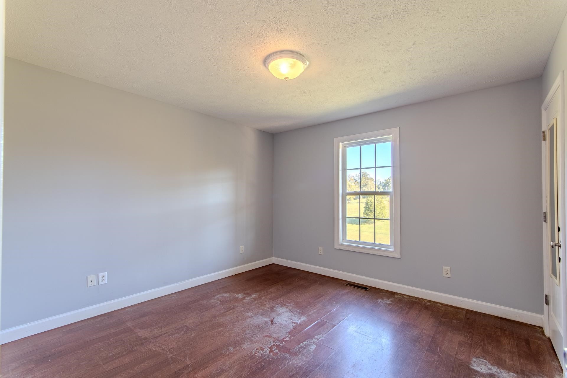 150 Hollis Way Adamsville, TN 38310 - Photo 19 of 37 an empty room with wooden floor and windows
