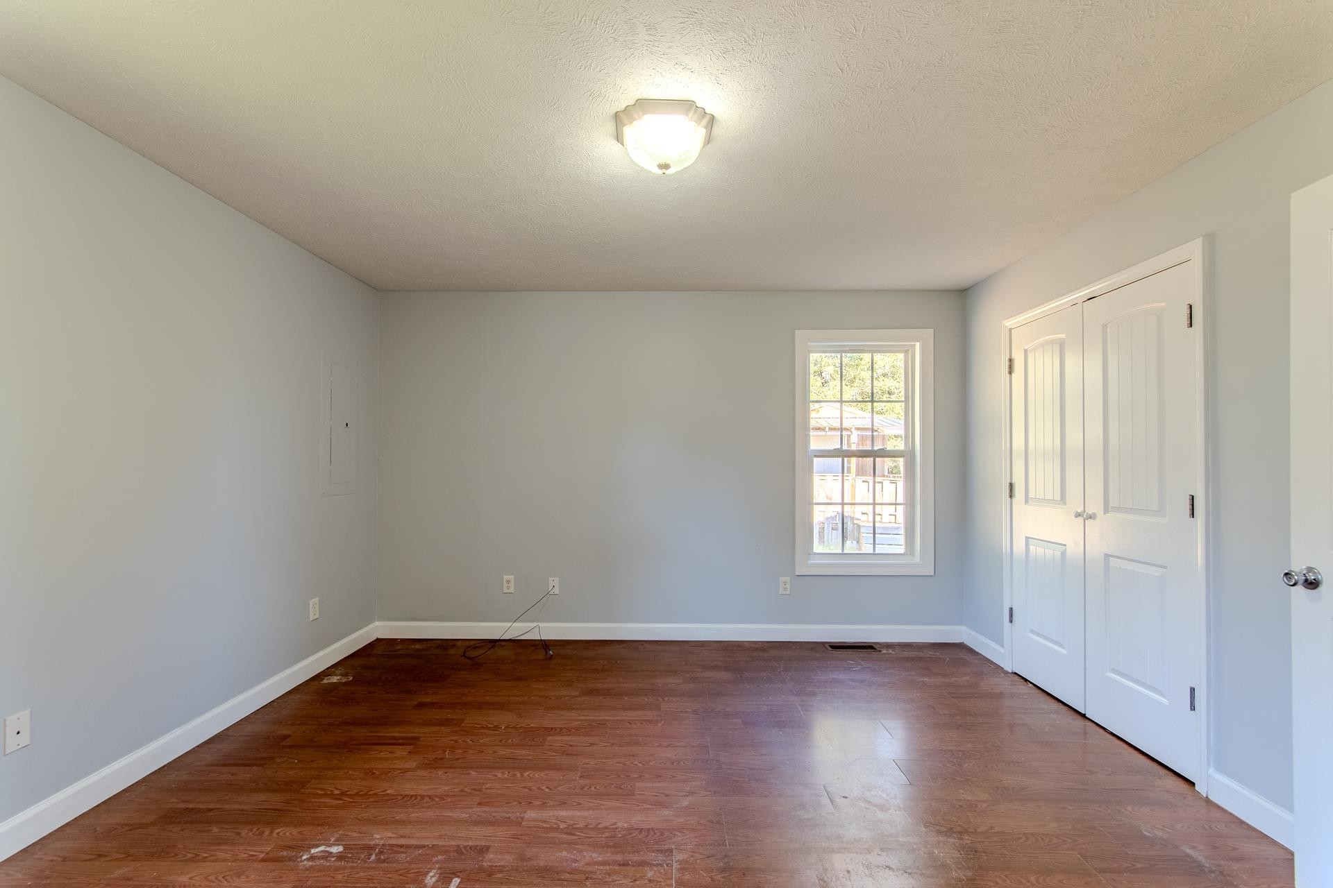 150 Hollis Way Adamsville, TN 38310 - Photo 21 of 37 an empty room with wooden floor and windows