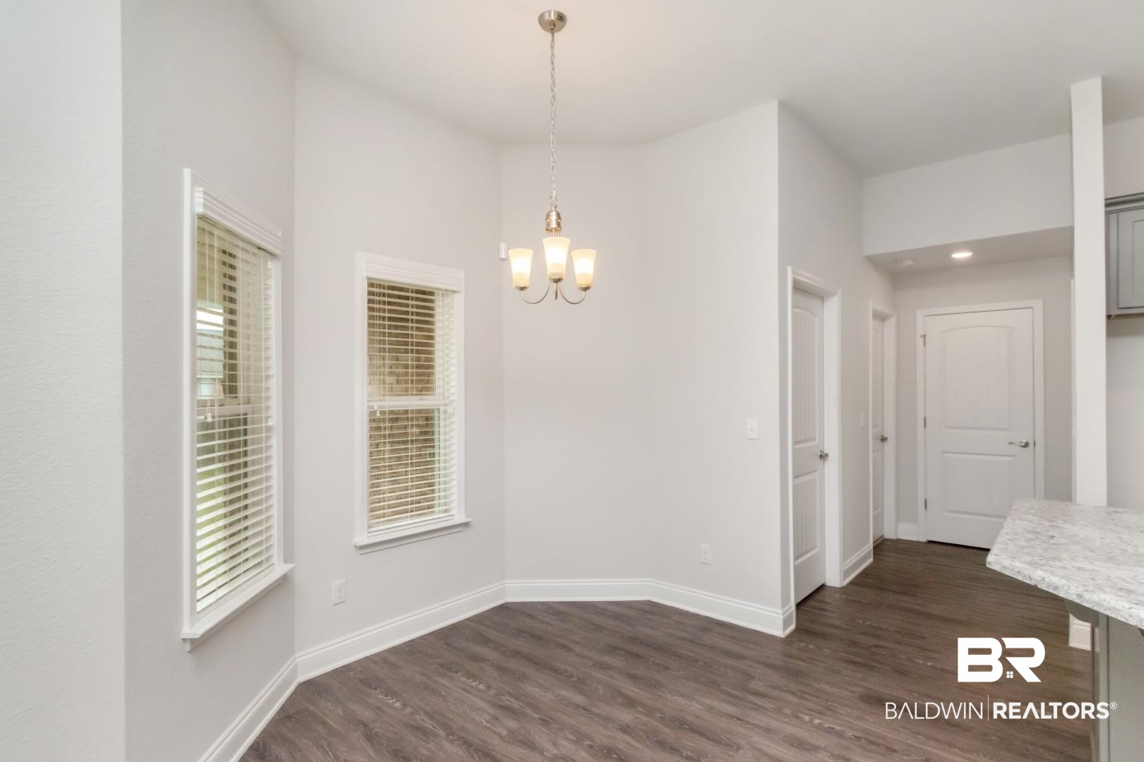 6632 Monarch Circle Mobile, AL 36618 - Photo 13 of 32 Unfurnished dining area with dark wood-style floors and a chandelier