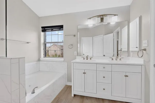 a bathroom with 2 sink tub and a mirror