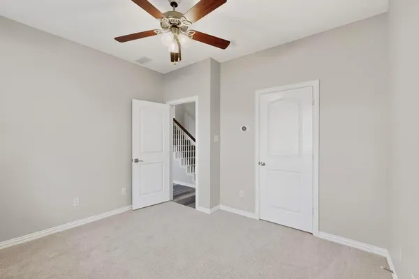 an empty room with closet and a chandelier fan
