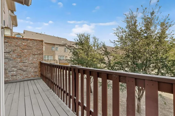 a balcony with wooden floor and fence