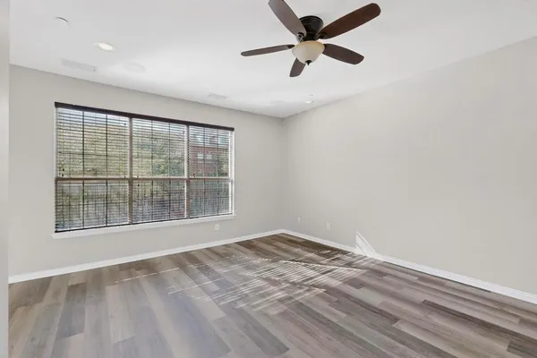 an empty room with a window and a fan