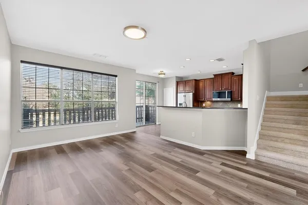 a view of a kitchen with wooden floor and a window