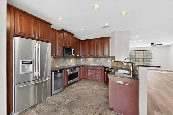 a kitchen with granite countertop stainless steel appliances and wooden cabinets