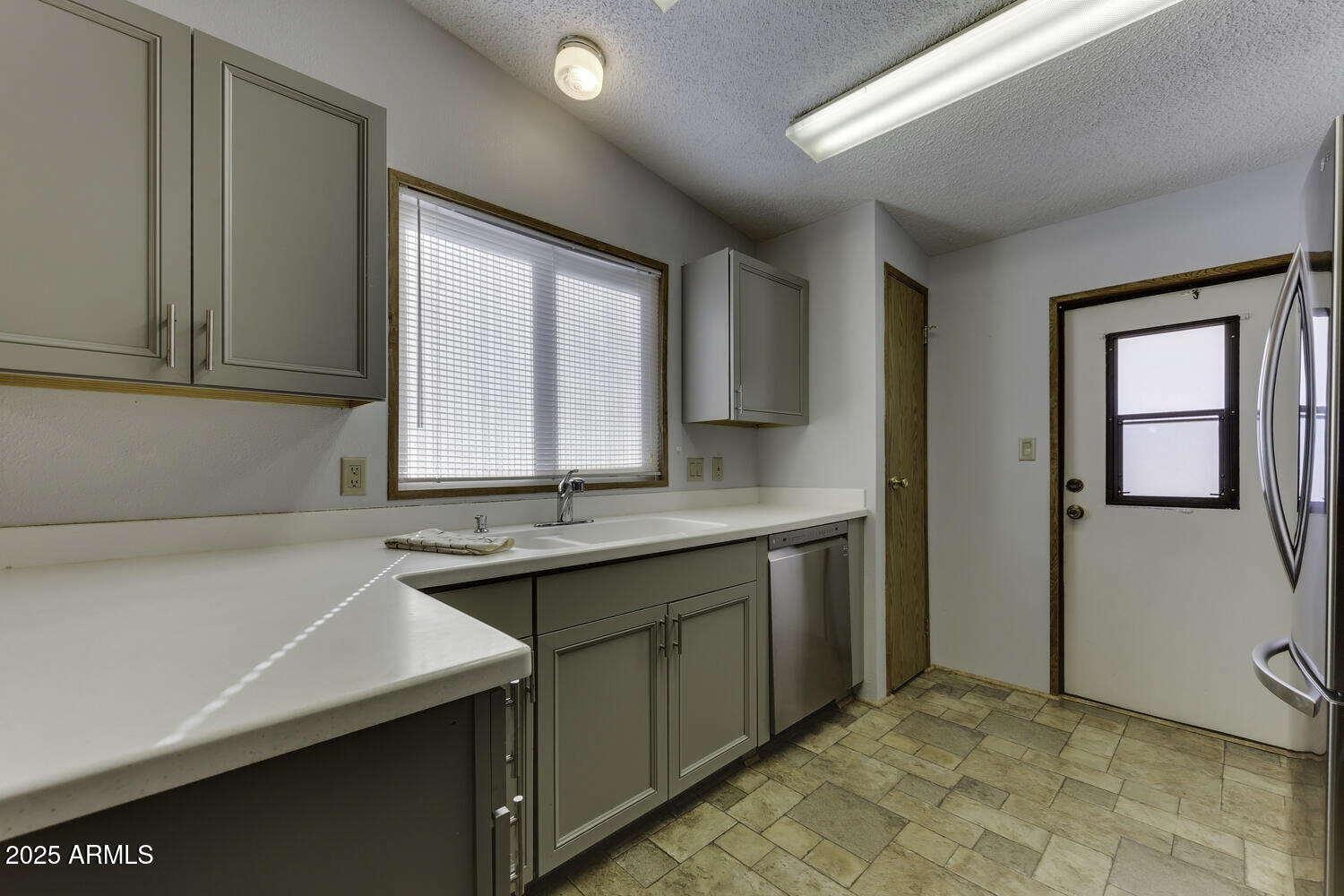 17200 West Bell Road, Unit 1745 Surprise, AZ 85374 - Photo 12 of 24 a kitchen with a sink and a refrigerator