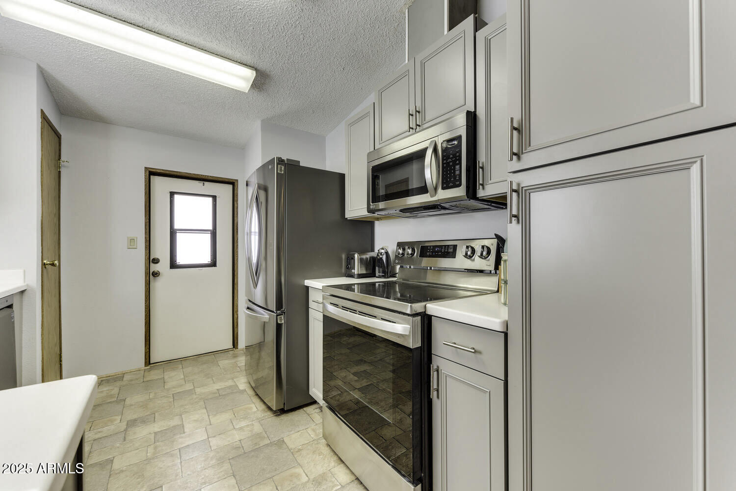 17200 West Bell Road, Unit 1745 Surprise, AZ 85374 - Photo 13 of 24 a kitchen with stainless steel appliances granite countertop a refrigerator stove and microwave