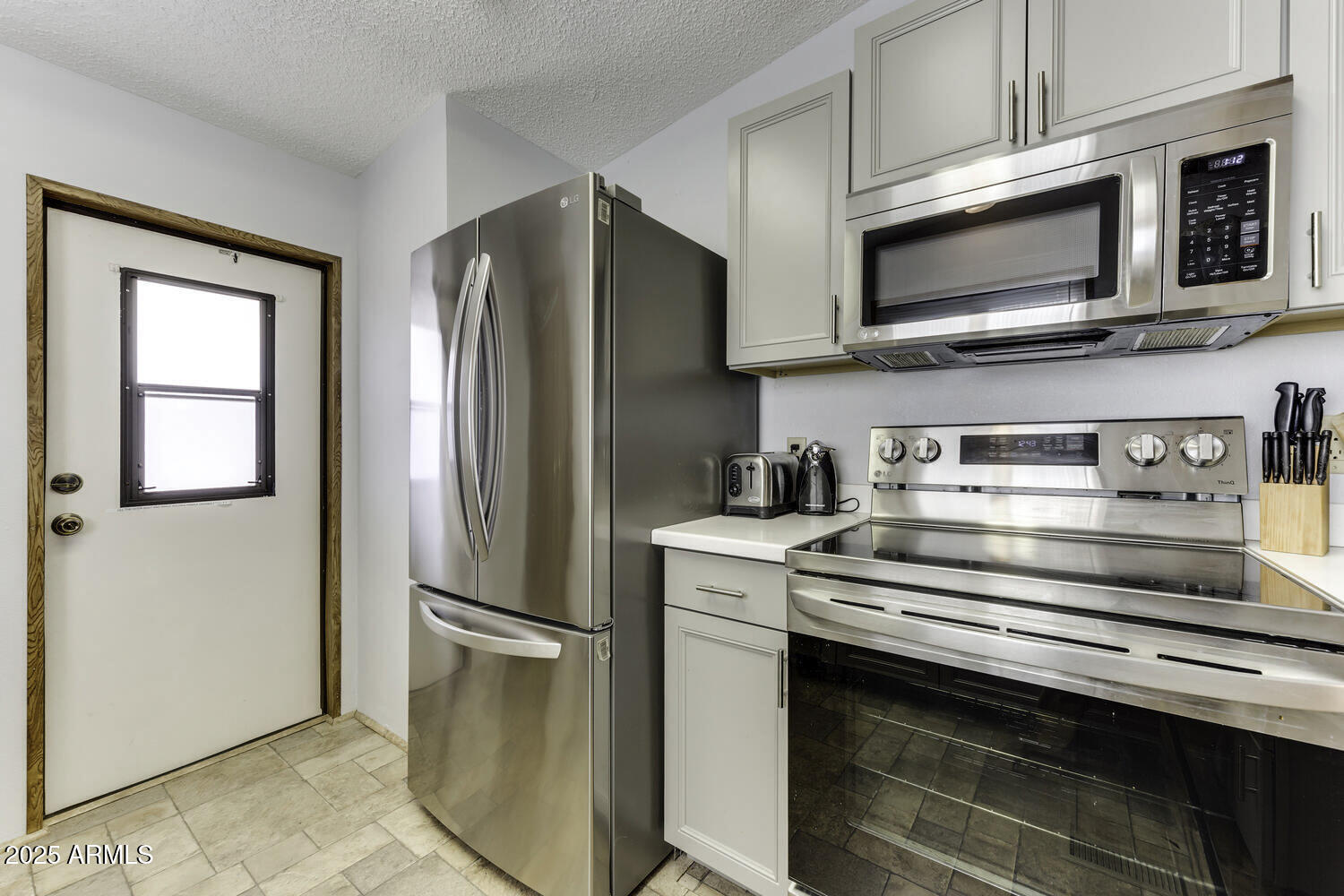 17200 West Bell Road, Unit 1745 Surprise, AZ 85374 - Photo 14 of 24 a kitchen with stainless steel appliances a refrigerator stove and microwave