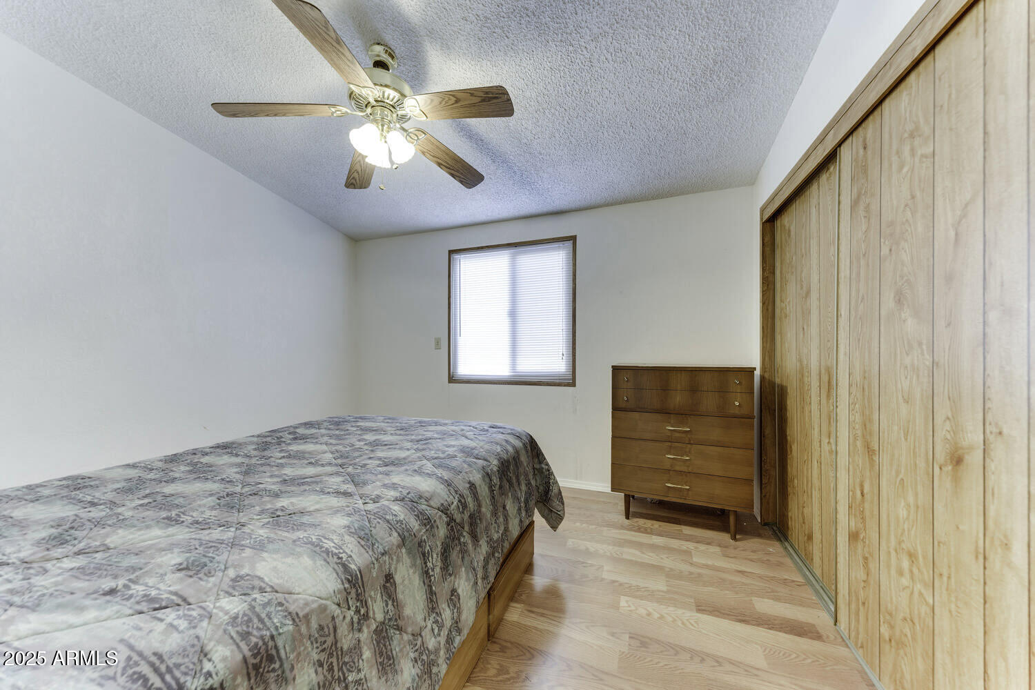 17200 West Bell Road, Unit 1745 Surprise, AZ 85374 - Photo 18 of 24 a bedroom with a bed and a chandelier