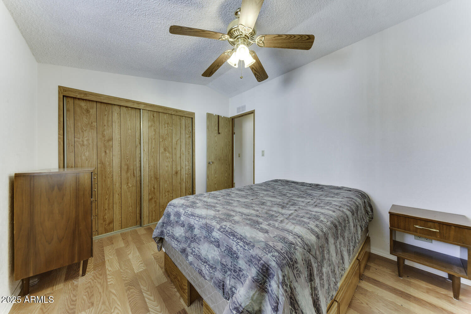 17200 West Bell Road, Unit 1745 Surprise, AZ 85374 - Photo 19 of 24 a bedroom with a bed and a chandelier
