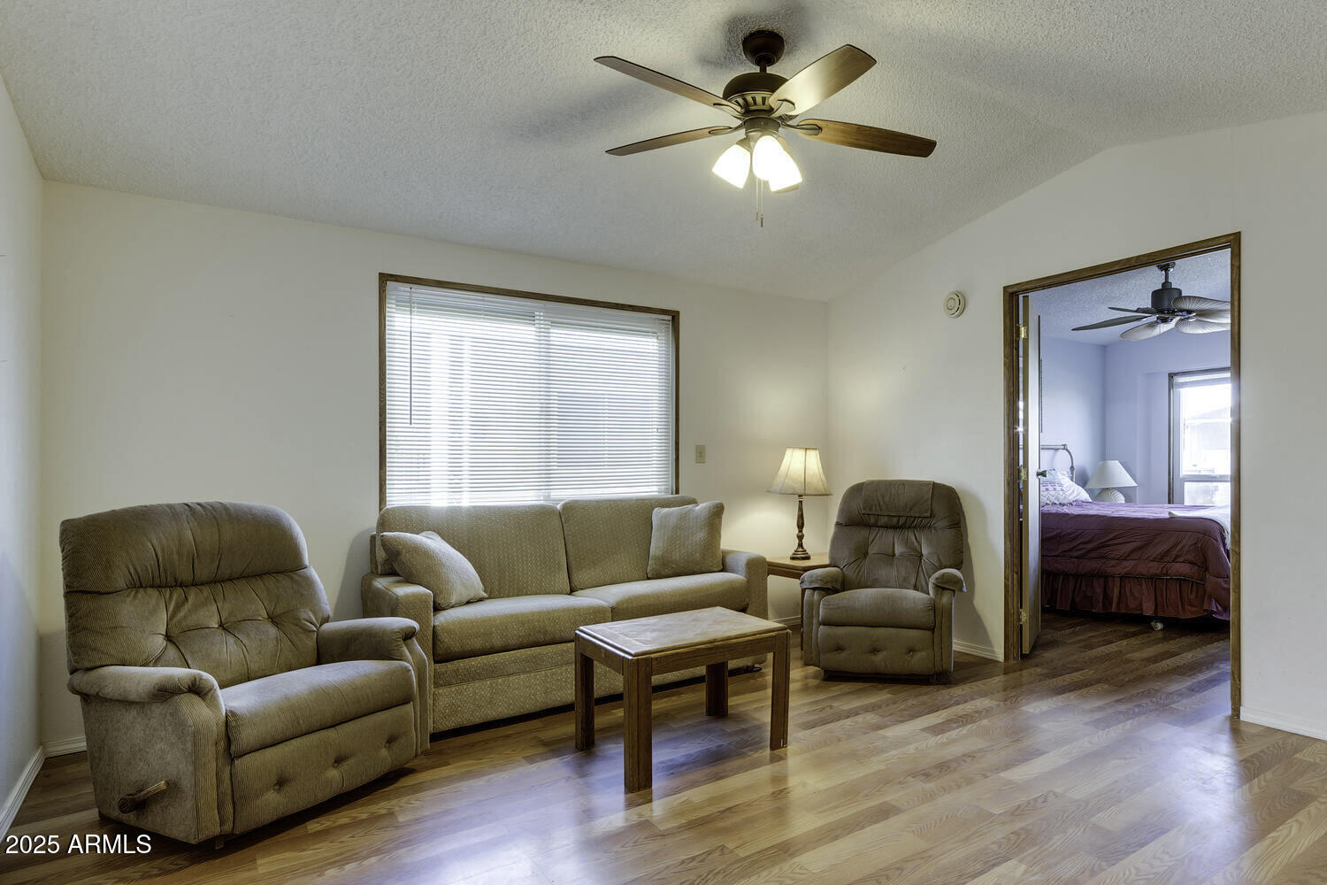 17200 West Bell Road, Unit 1745 Surprise, AZ 85374 - Photo 2 of 24 a living room with furniture a ceiling fan a lamp and a window