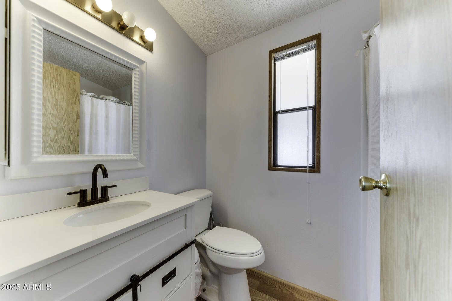 17200 West Bell Road, Unit 1745 Surprise, AZ 85374 - Photo 21 of 24 a bathroom with a sink a toilet and mirror