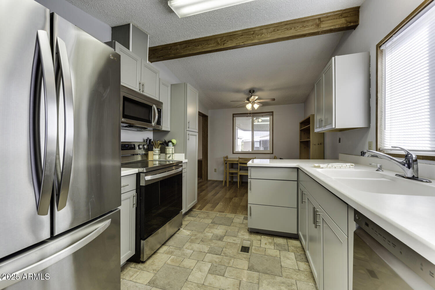 17200 West Bell Road, Unit 1745 Surprise, AZ 85374 - Photo 3 of 24 a kitchen with a sink cabinets and stainless steel appliances