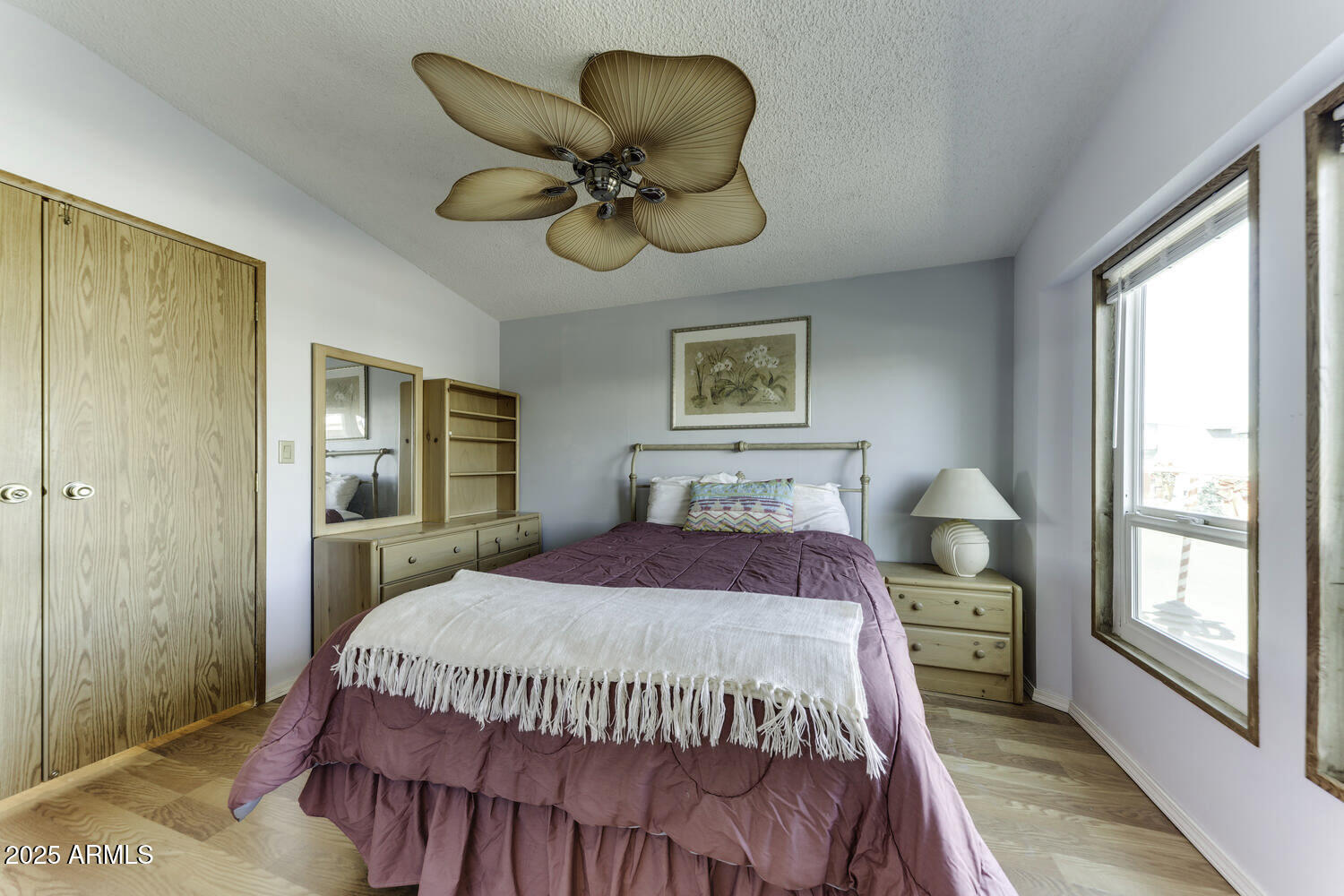 17200 West Bell Road, Unit 1745 Surprise, AZ 85374 - Photo 4 of 24 a bedroom with a bed and a chandelier