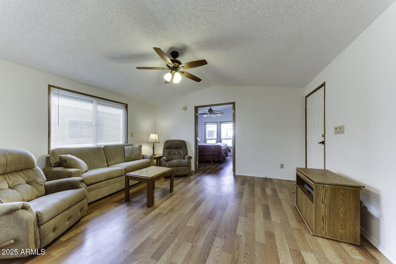 17200 West Bell Road, Unit 1745 Surprise, AZ 85374 - Photo 7 of 24 a living room with furniture a ceiling fan a lamp and a window