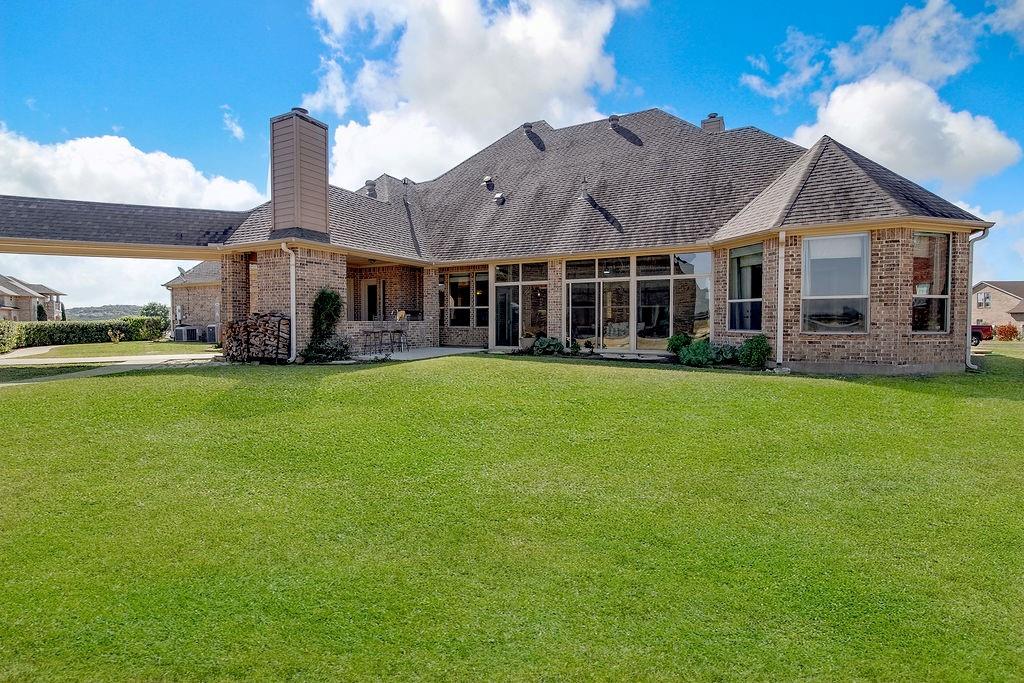 117 Citation Drive Cresson, TX 76035 - Photo 39 of 40 Back of house featuring a chimney, a lawn, and brick siding